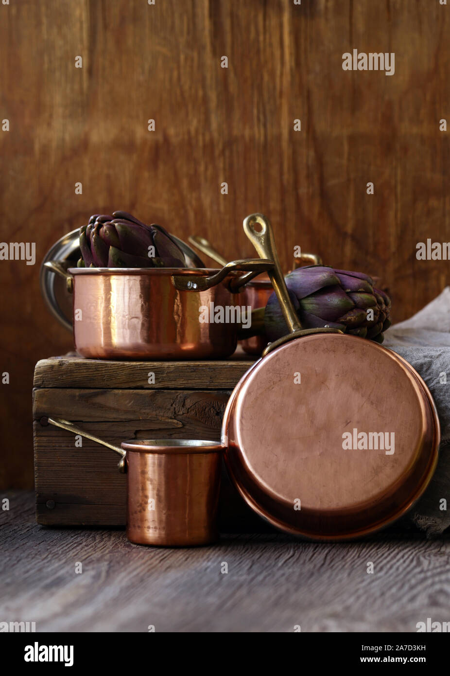 Utensili di rame, pentole, siviera e pan su sfondo di legno Foto stock -  Alamy