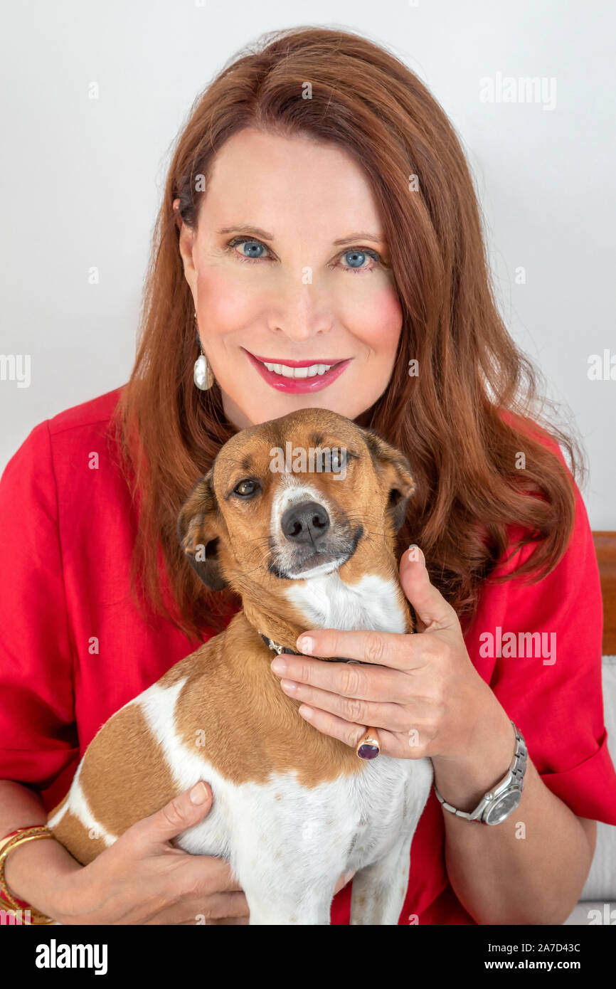 Donna sorridente in posa con il suo cane Foto Stock