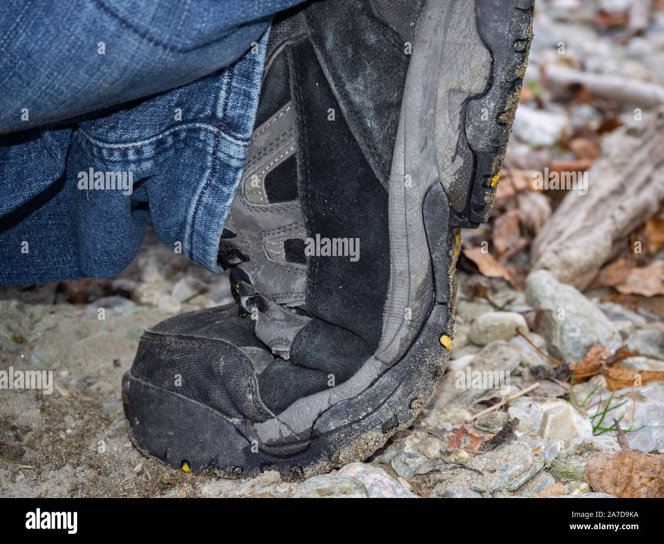 Una calzatura Trekking sul suolo sabbioso Foto Stock