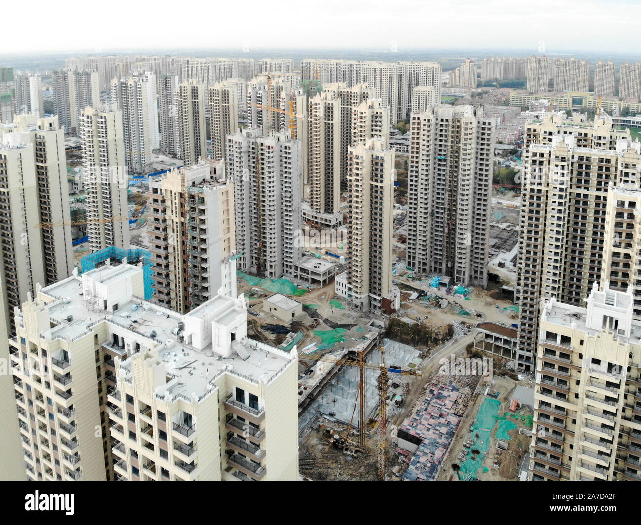 Vista aerea della massiccia costruzione siti in costruzione con gru a torre. Blocchi di costruzione appartamento in costruzione in parte di sviluppo della città di Tianjin, in Cina. Station wagon sito in costruzione. Foto Stock