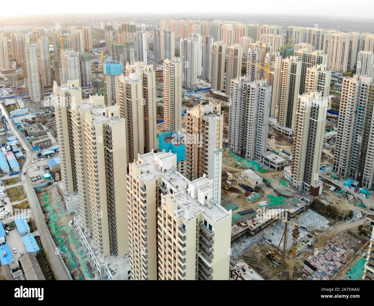 Vista aerea della massiccia costruzione siti in costruzione con gru a torre. Blocchi di costruzione appartamento in costruzione in parte di sviluppo della città di Tianjin, in Cina. Station wagon sito in costruzione. Foto Stock