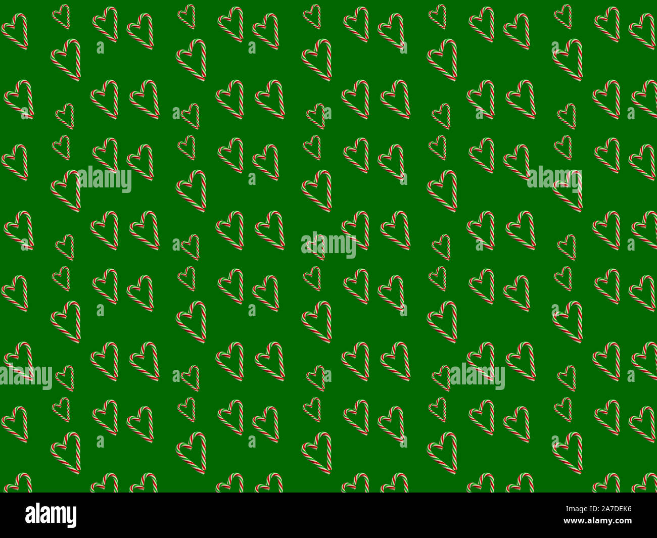 Little Christmas candy cuori su sfondo verde. Perfetta la carta di avvolgimento concetto, sfondo, pattern per il tessuto. Foto Stock