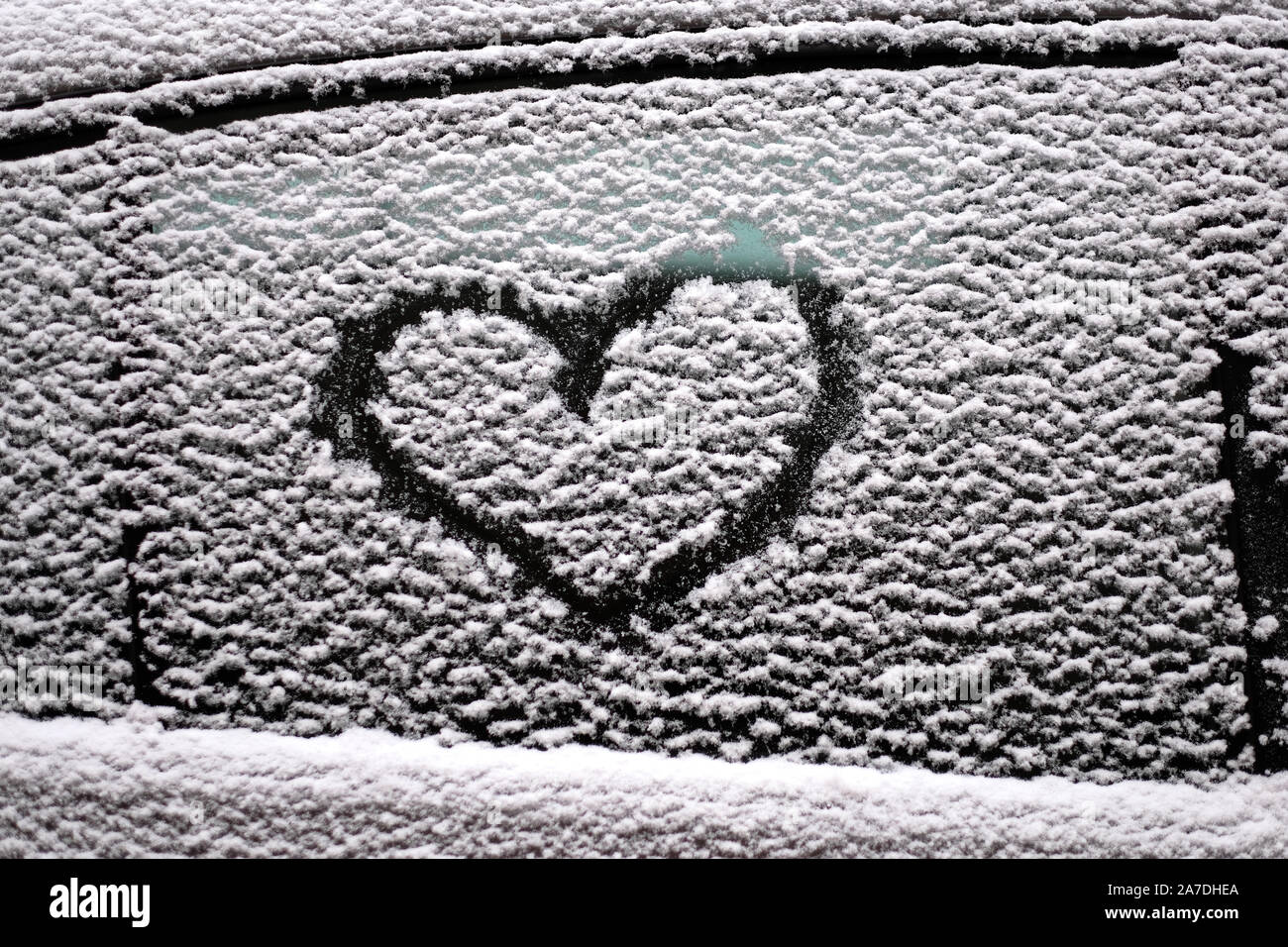 Disegno astratto di un cuore sul lato finestrino di una macchina coperto con neve bagnata Foto Stock Disegno astratto di un cuore sul lato finestrino di una macchina coperto con neve bagnata Foto Stock