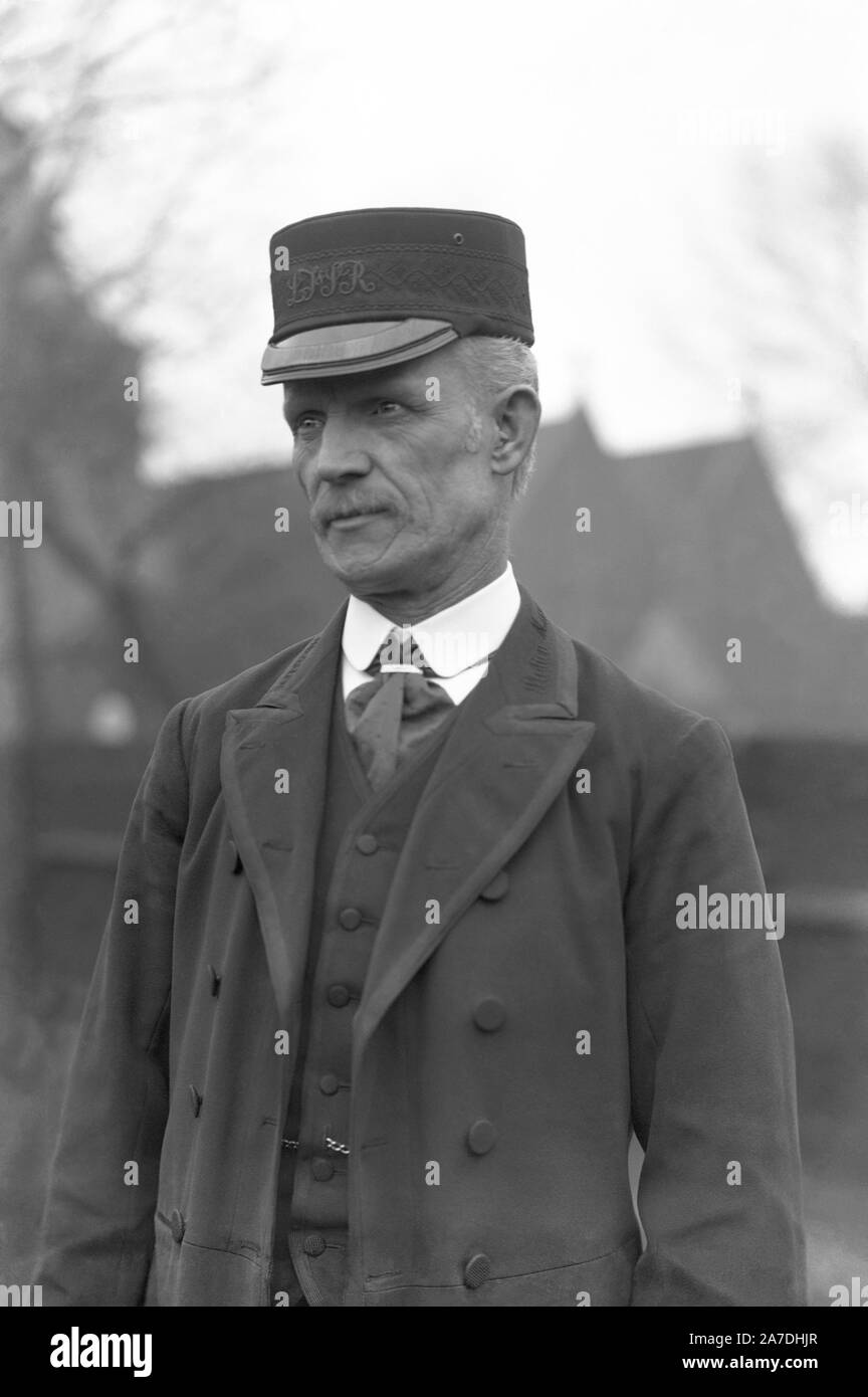 Una stazione ferroviaria in uniforme dipendente di Londra, Tilbury e Southend Railway (LTSR), Essex, Inghilterra, Regno Unito c.1910. La sua uniforme smart include un berretto con le iniziali ricamate del LTSR plus un doppiopetto giacca e gilet con una camicia bianca e la cravatta al di sotto. Foto Stock