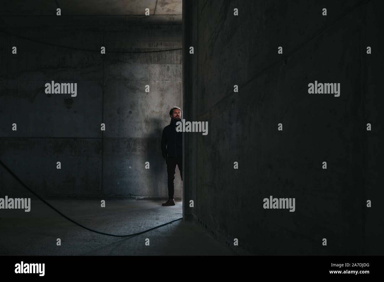 Uomo in piedi all'interno di un vuoto di un edificio in calcestruzzo Foto Stock