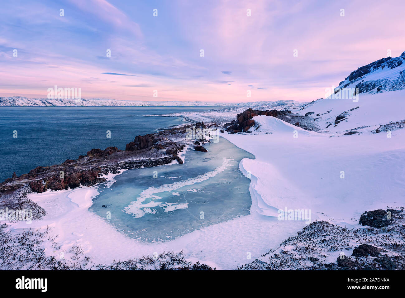 Un piccolo lago ghiacciato e il Mare di Barents costa. Teriberka, Regione di Murmansk, la penisola di Kola. La Russia. Il focus principale sul lago ghiacciato. Foto Stock