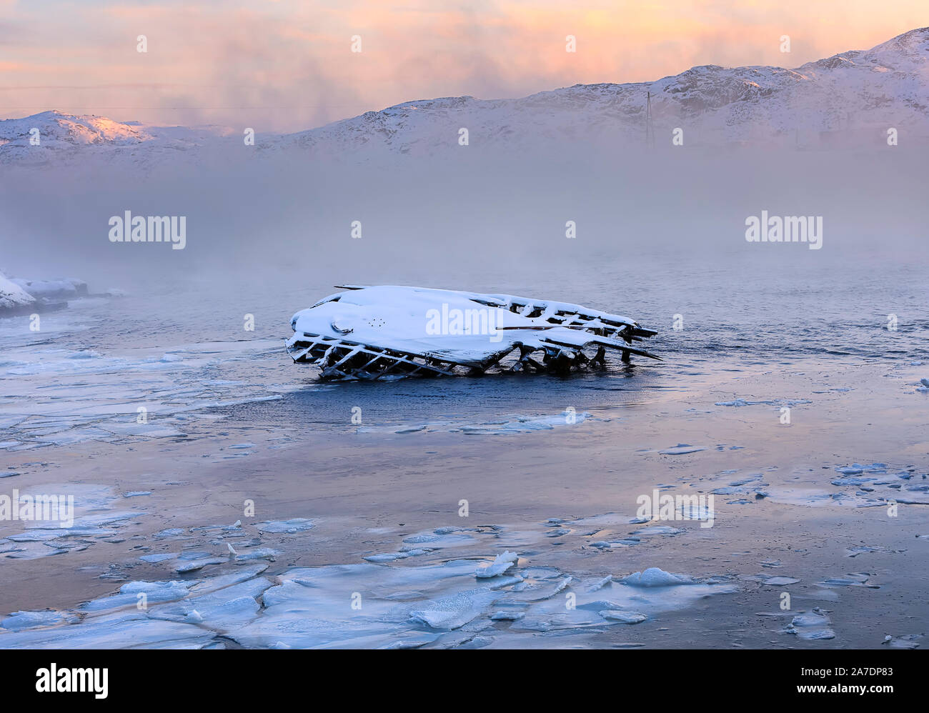 Metallo e legno parti della vecchia nave con reti a circuizione sul Mare di Barents costa a sunrise. Teriberka, Regione di Murmansk. La Russia. Luce morbida con fumo di mare Foto Stock