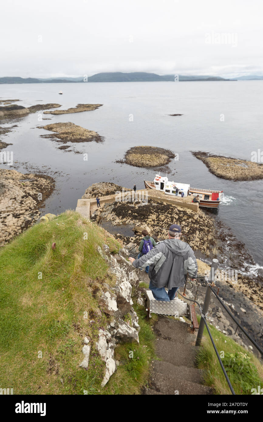 Turisti visitano le colonne di basalto sulla isola di staffa, Ebridi Interne, Scotland, Regno Unito Foto Stock