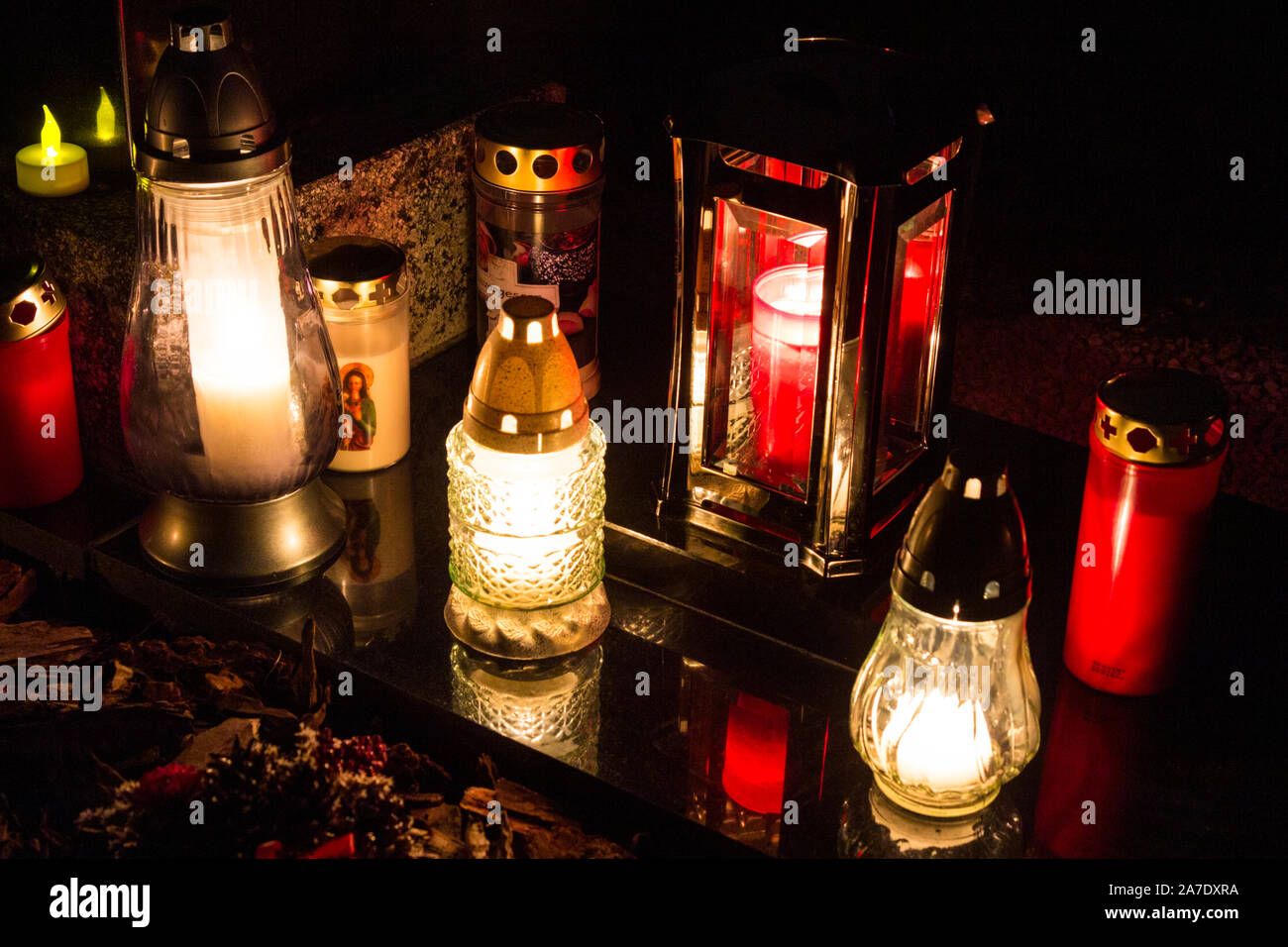 Candele accese sulla pietra tombale nella vecchia Szent Mihaly temeto (St. Michael cimitero) il giorno di Tutti i Santi, Sopron, Ungheria Foto Stock