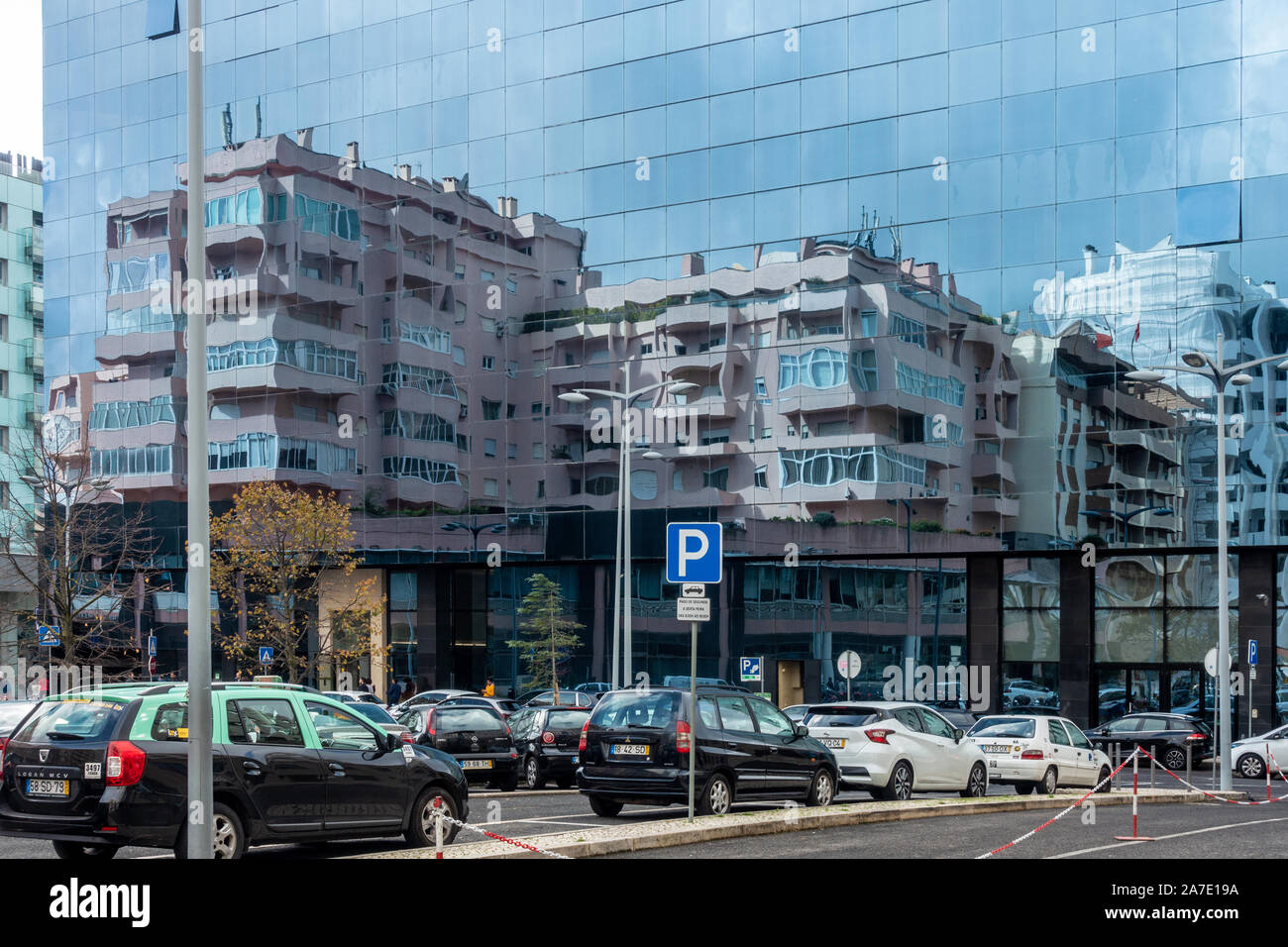 Blocchi di appartamenti riflessa in un vetro moderno edificio per uffici a Lisbona, Portogallo. Foto Stock