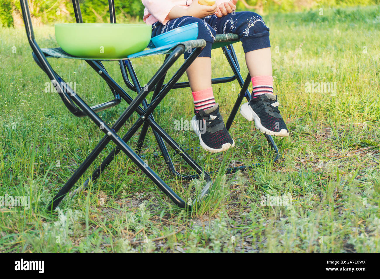 Gambe di capretto piccolo ragazza seduta su una sedia Foto Stock