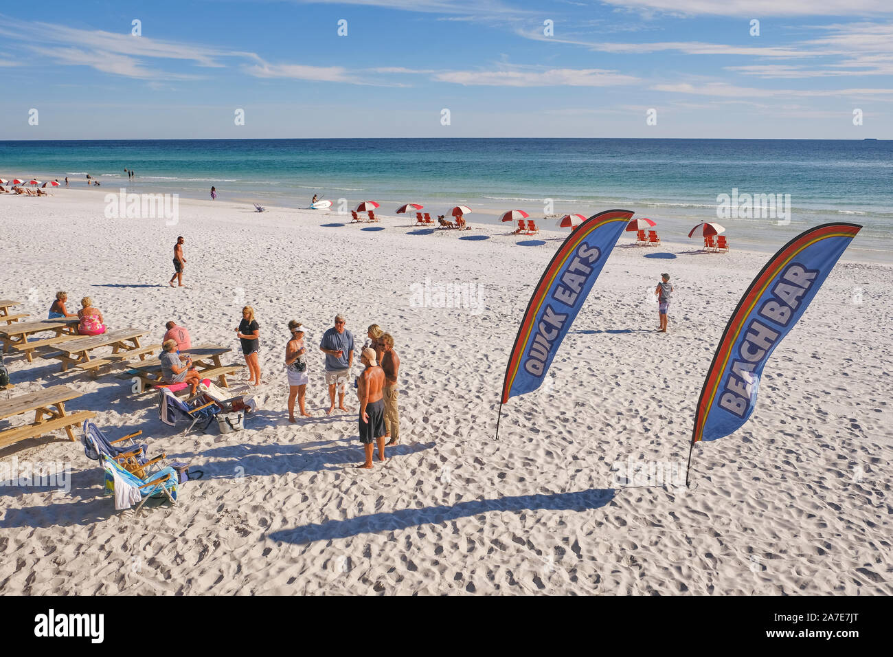 La gente sulla spiaggia di sabbia bianca vicino ad un bar sulla spiaggia usa dei banner per pubblicizzare cibo e bevande al ristorante Pombano Joe's iMiramar Beach Florida, USA. Foto Stock