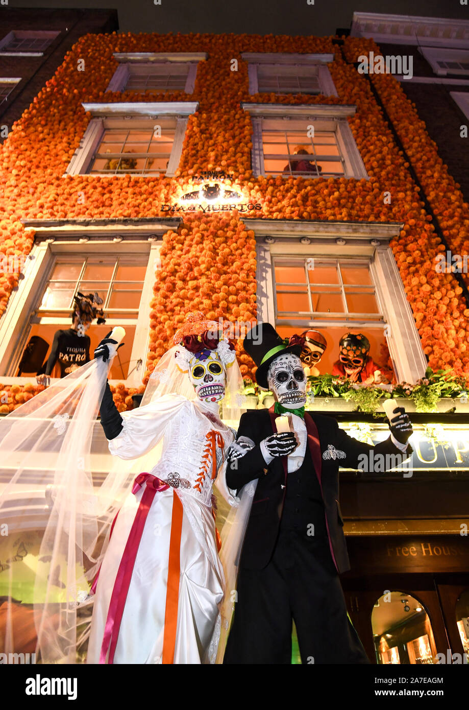 Solo uso editoriale tradizionale messicano Dia de Muertos caratteri come la Calavera Catrina, farfalle monarca e zucchero teschi, festeggiano per le strade di Soho il Patron Tequila il Giorno dei Morti celebrazioni, Londra. Foto Stock
