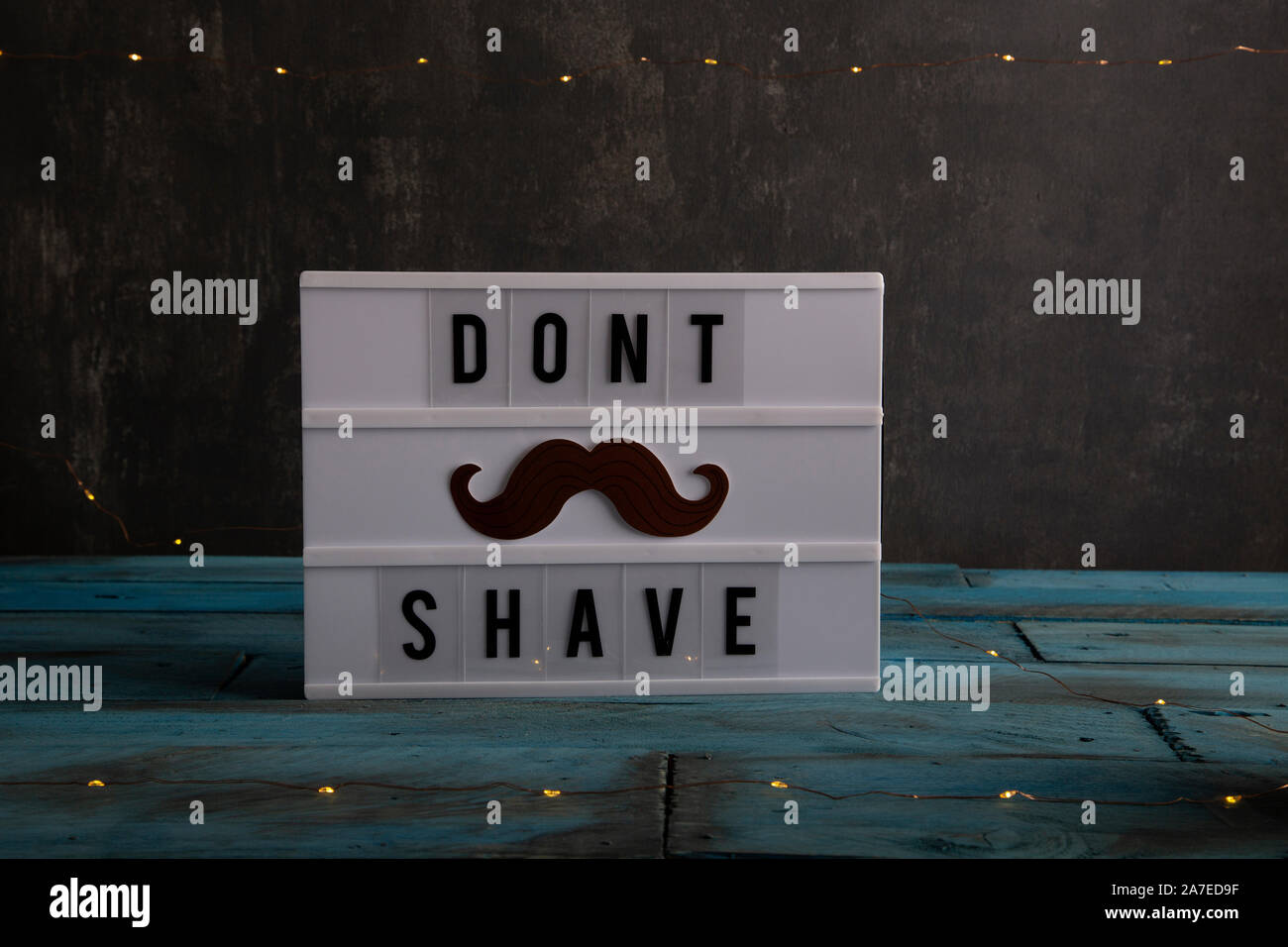 Visual Lightbox con le parole dont radere e un bogite sullo sfondo con le luci a led e vintage in legno di colore blu Foto Stock