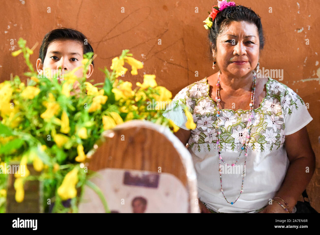 Famiglia di Merida davanti alla loro famiglia altare durante Hanal Pixan che è la celebrazione del Giorno dei morti che ha originato dalla cultura Maya. Merida, Messico Foto Stock