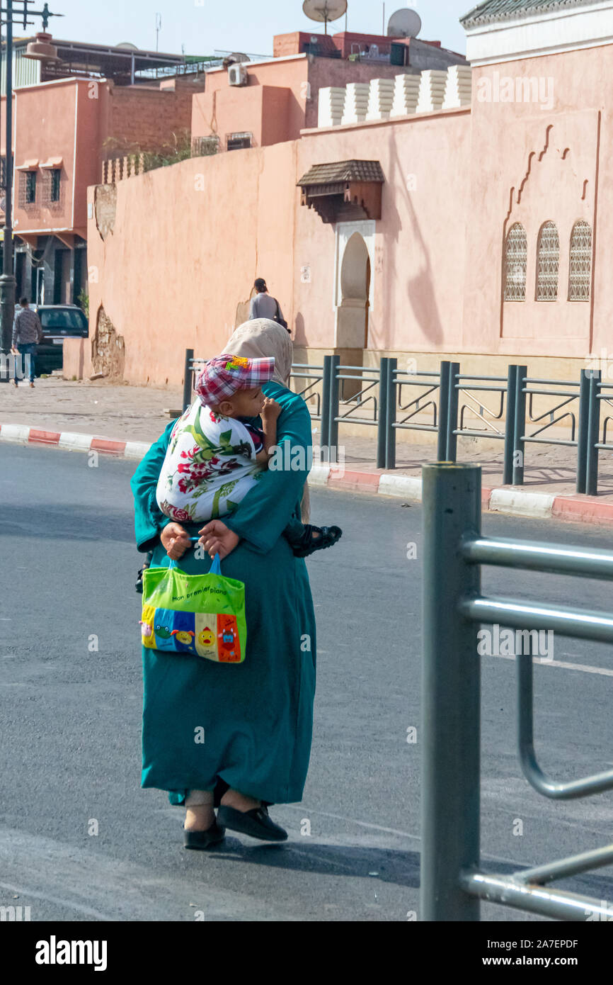 La donna araba con il bambino dietro il suo ritorno nella città di Marrakech. Il Marocco Ottobre 2019 Foto Stock