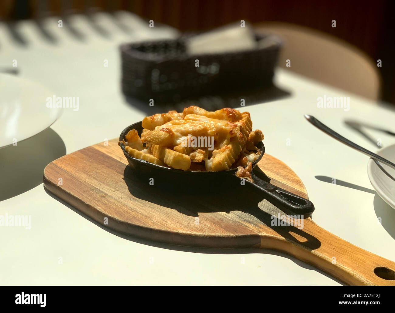 Il cucinato le patatine fritte in padella e piatto in legno Foto Stock