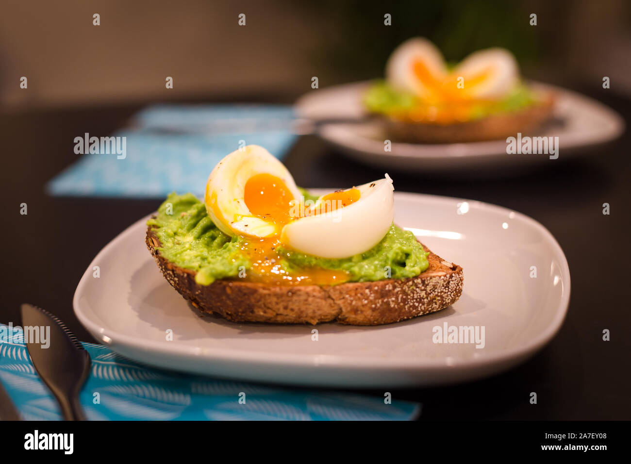 Due piatti con una sana colazione di avocado su toast con un uovo bollito. Foto Stock