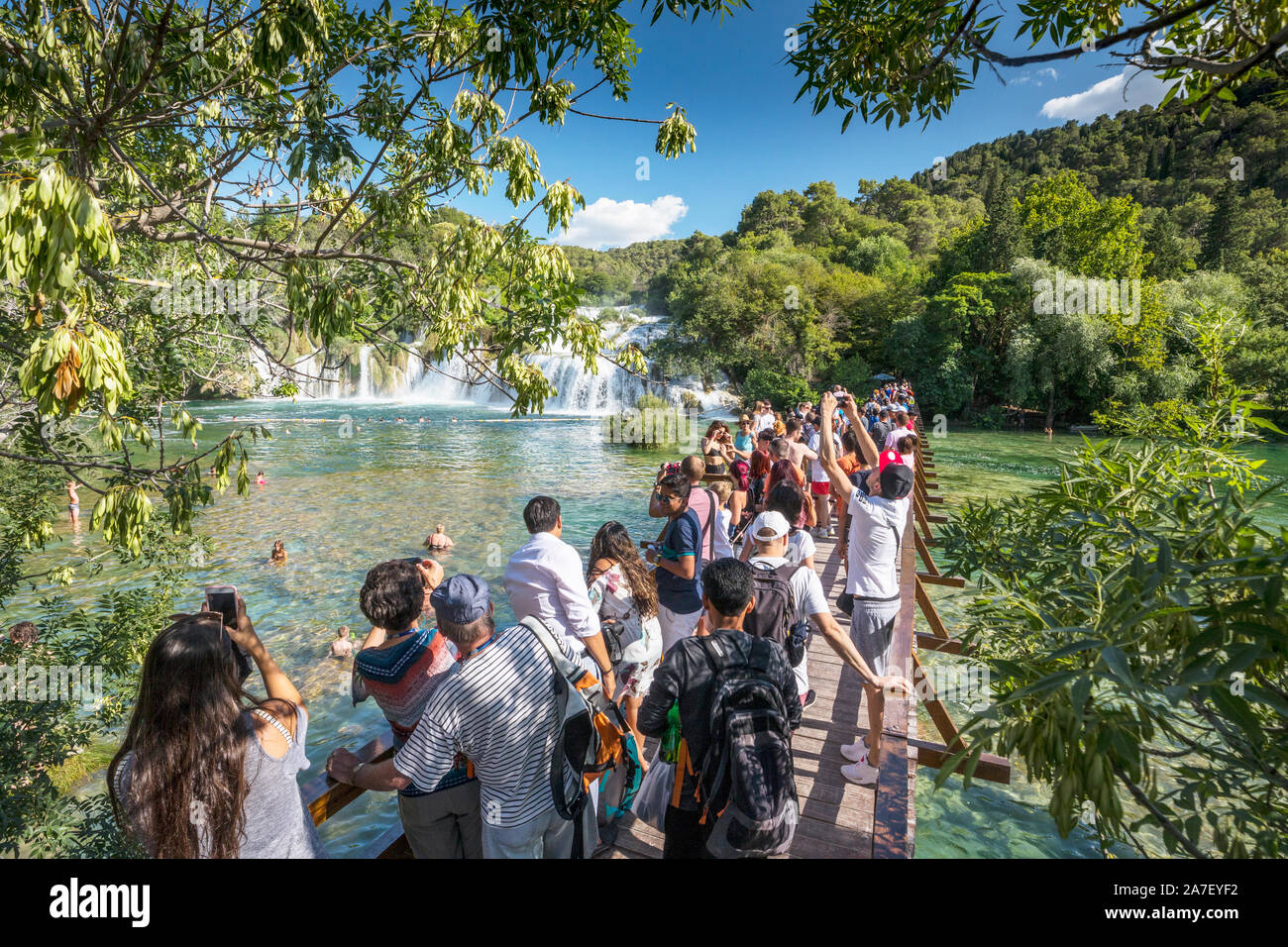 I turisti sul ponte a guardare le cascate nel parco nazionale di Krka in Croazia Foto Stock