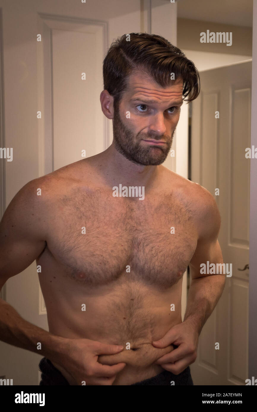 Un giovane caucasico si svergonò con il grasso del ventre. Foto Stock