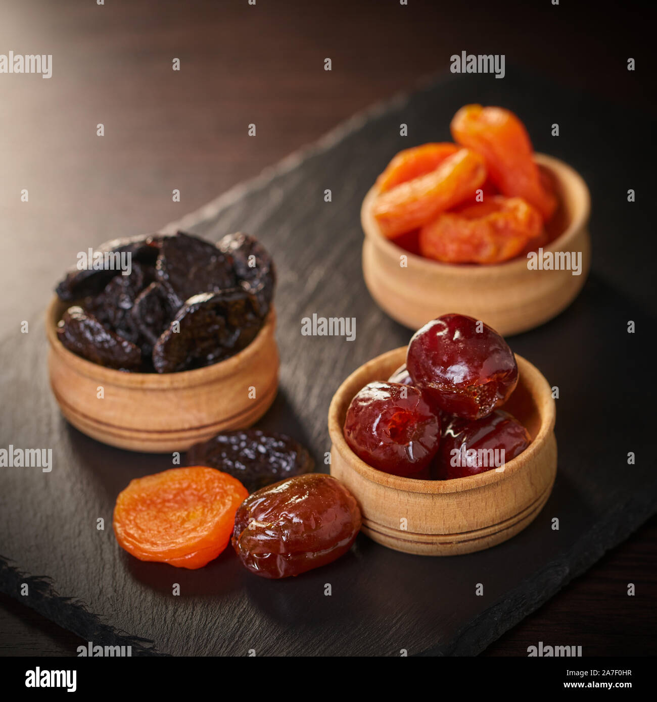 Un assortimento di frutta secca in ciotole di legno su un tavolo Foto Stock