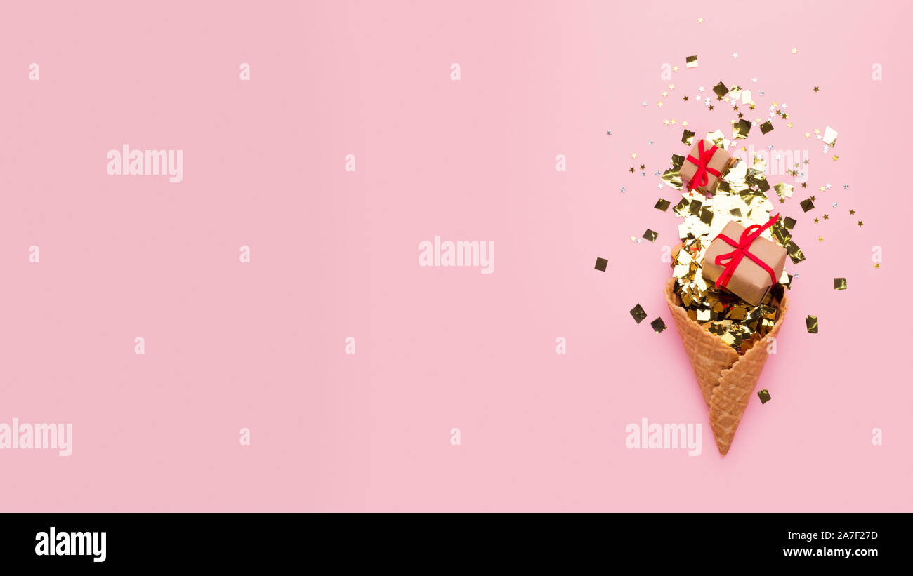 Waffle avvisatore acustico con doni e coriandoli oro su sfondo rosa Foto Stock