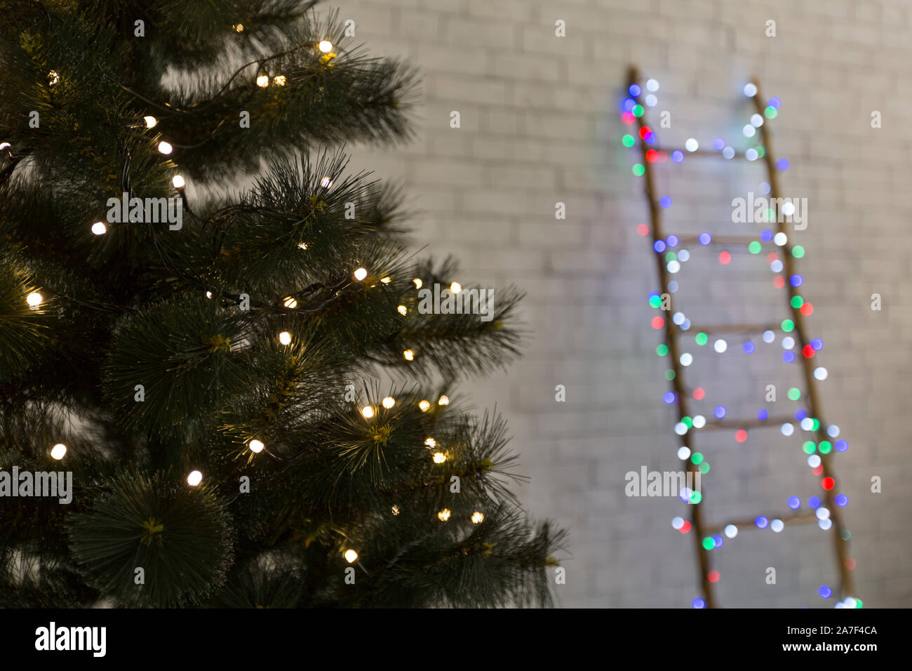 Natale pino con scaletta sfocata sullo sfondo Foto Stock
