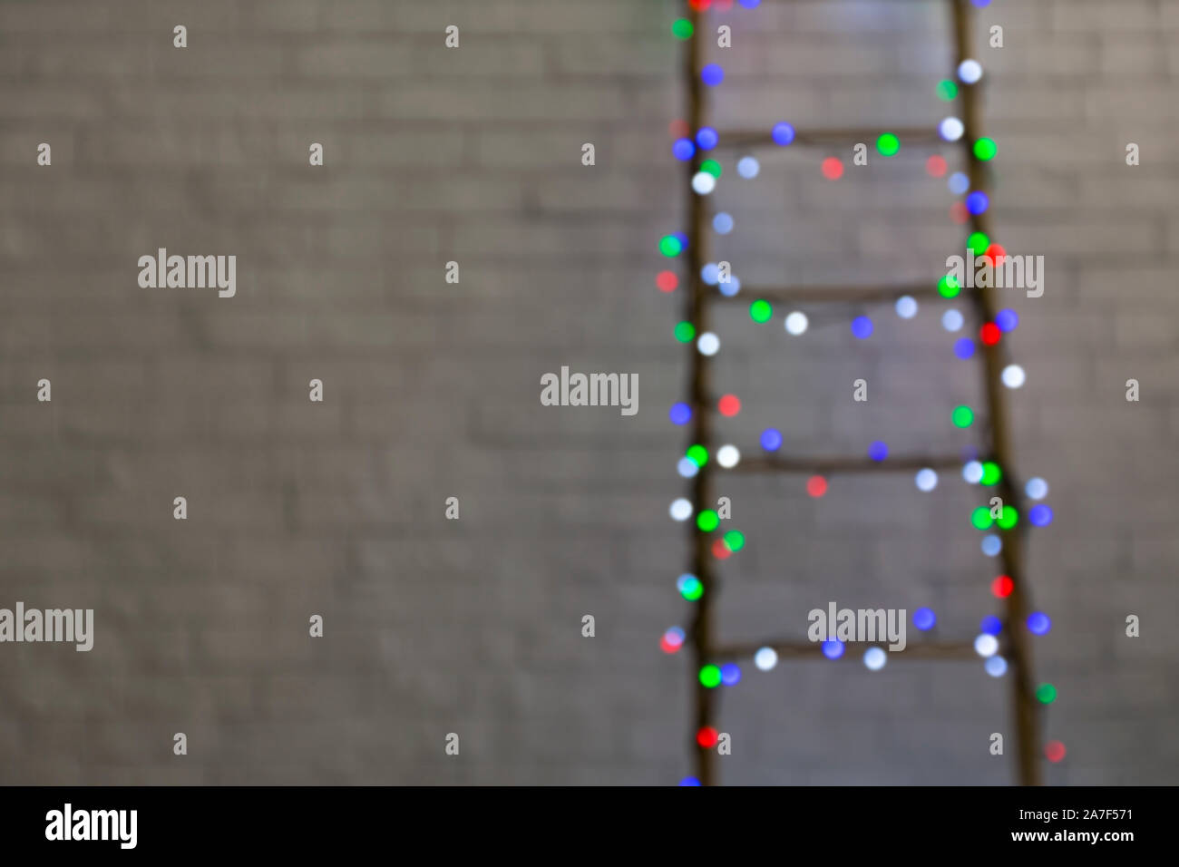 Sfocata scaletta di Natale con luci colorate su muro in mattoni Foto Stock