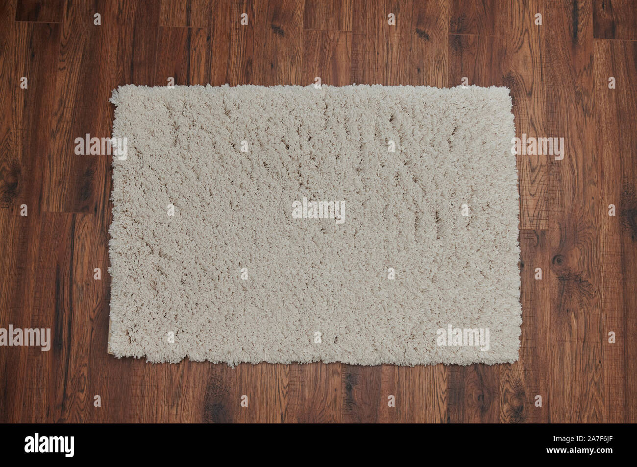 Colore beige tappeto giaceva sul legno marrone casa piano Foto Stock