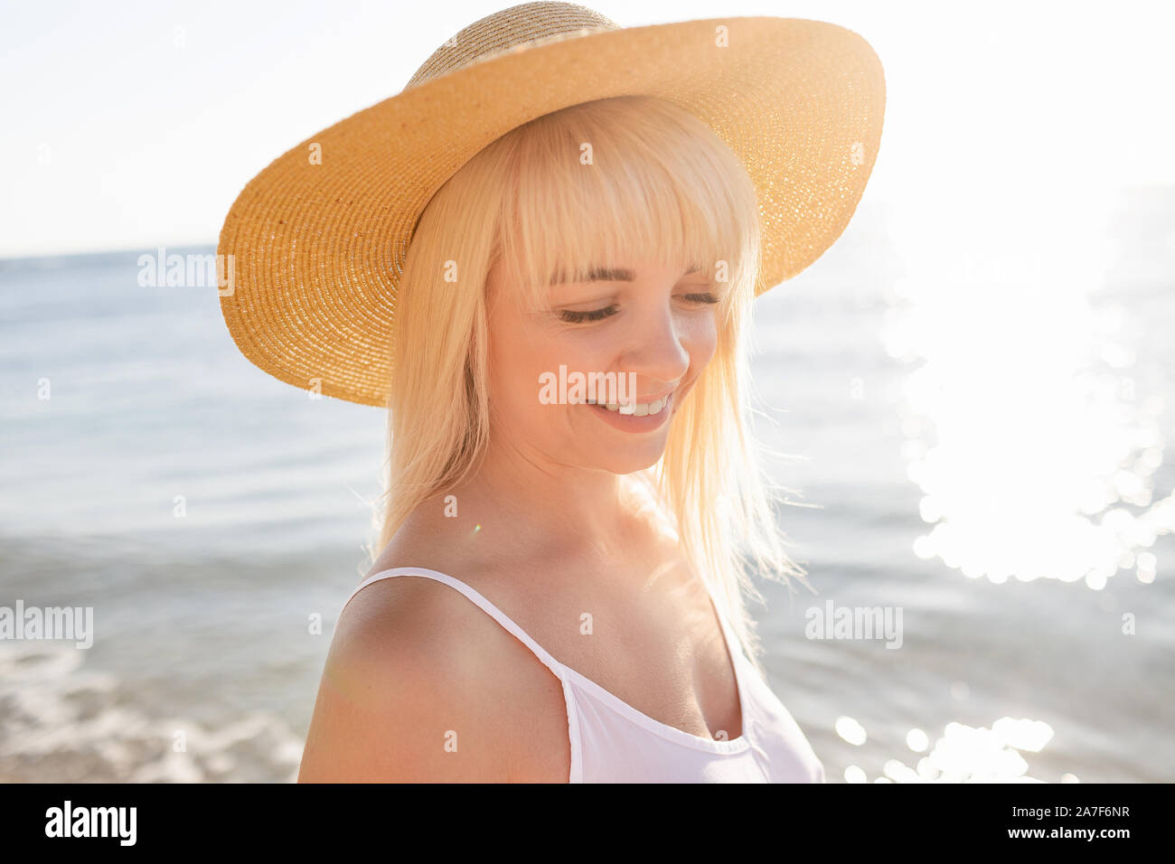 Felice bella donna bionda in hat in spiaggia godendo le vacanze estive Foto Stock