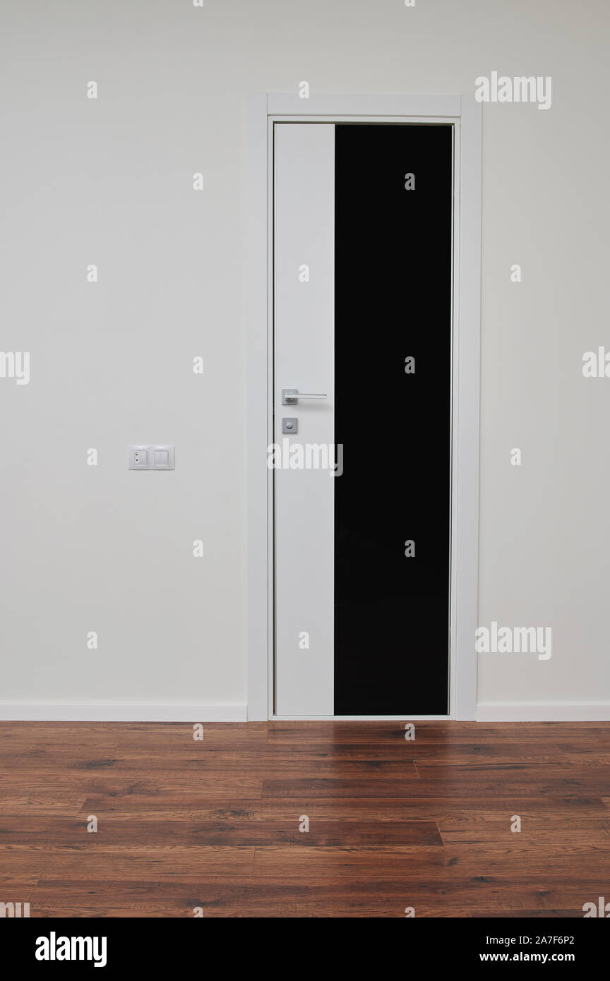 Home porta con telaio nero in appartamento a muro bianco sullo sfondo Foto Stock