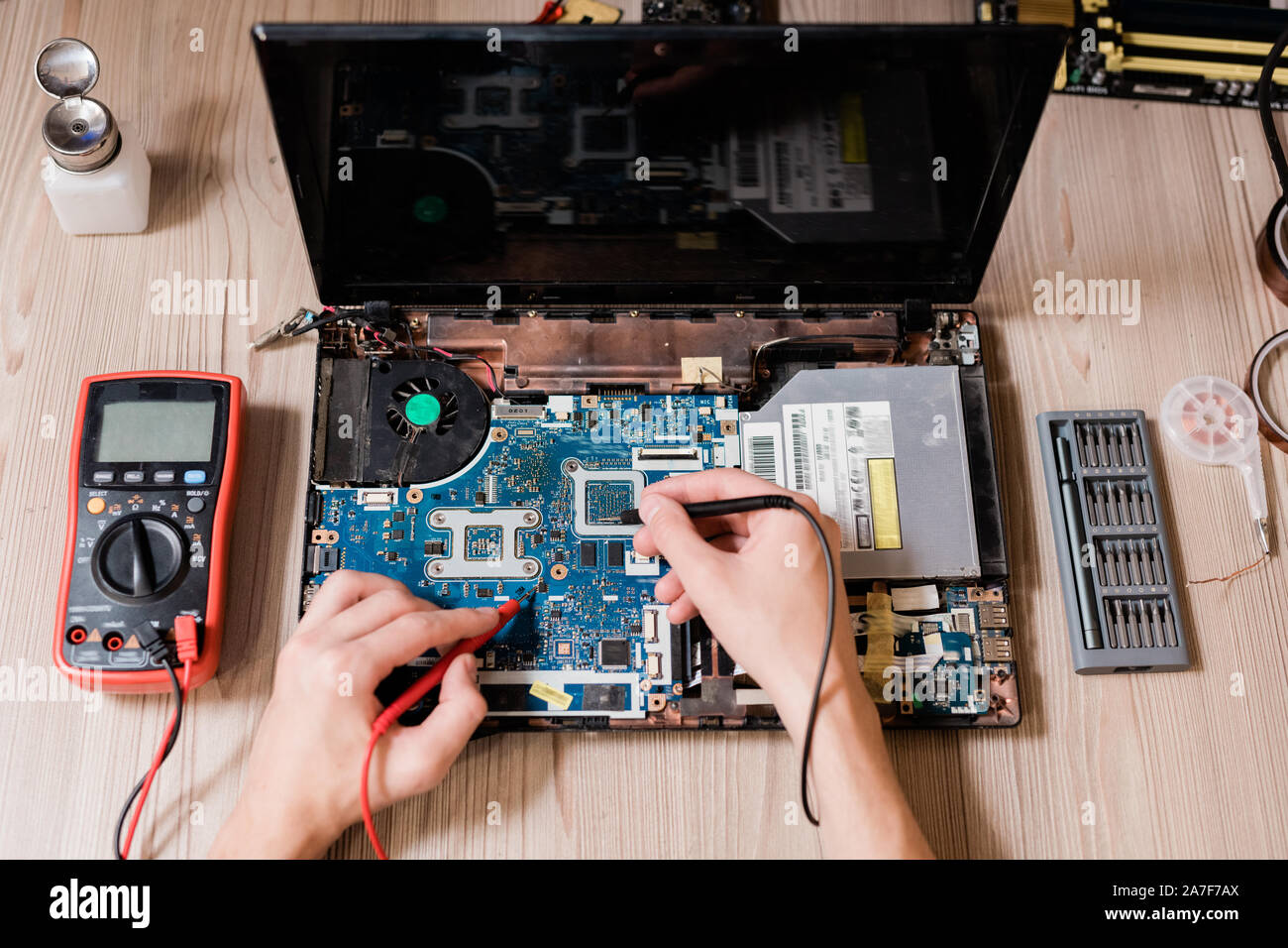 Le mani del maestro contemporaneo utilizzando piccole saldature-ferri per riparare il computer portatile Foto Stock