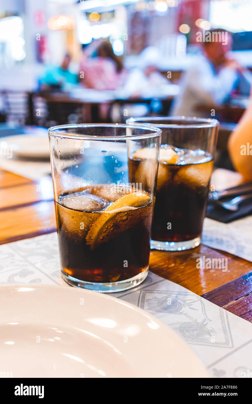 Due bicchieri di coca cola a freddo con ghiaccio e limone su un ristorante tabella Foto Stock