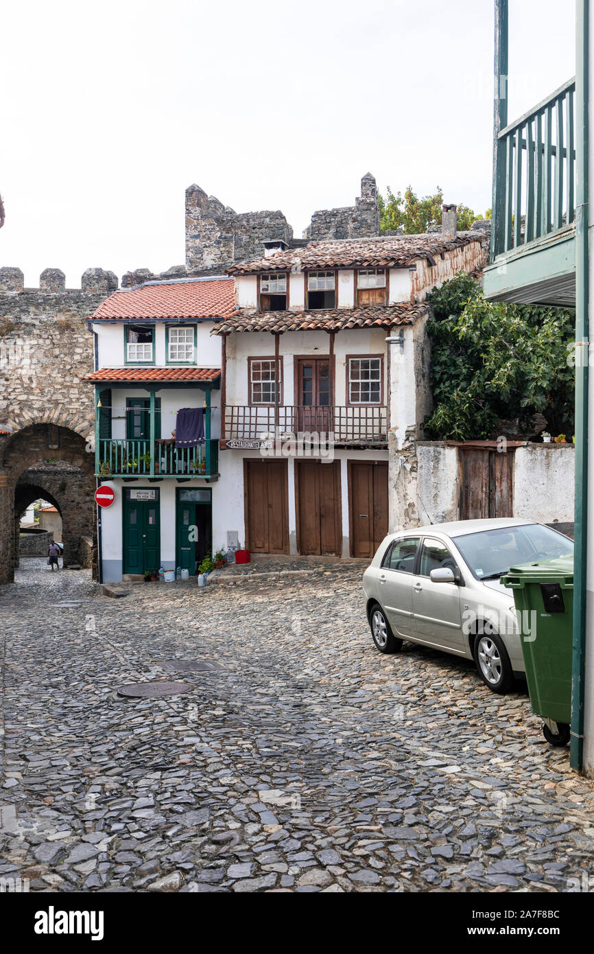 Case antiche, alcune delipidati, circostante il castello di epoca medioevale e all'interno del castello medievale di pareti a Bragance, Portogallo Foto Stock