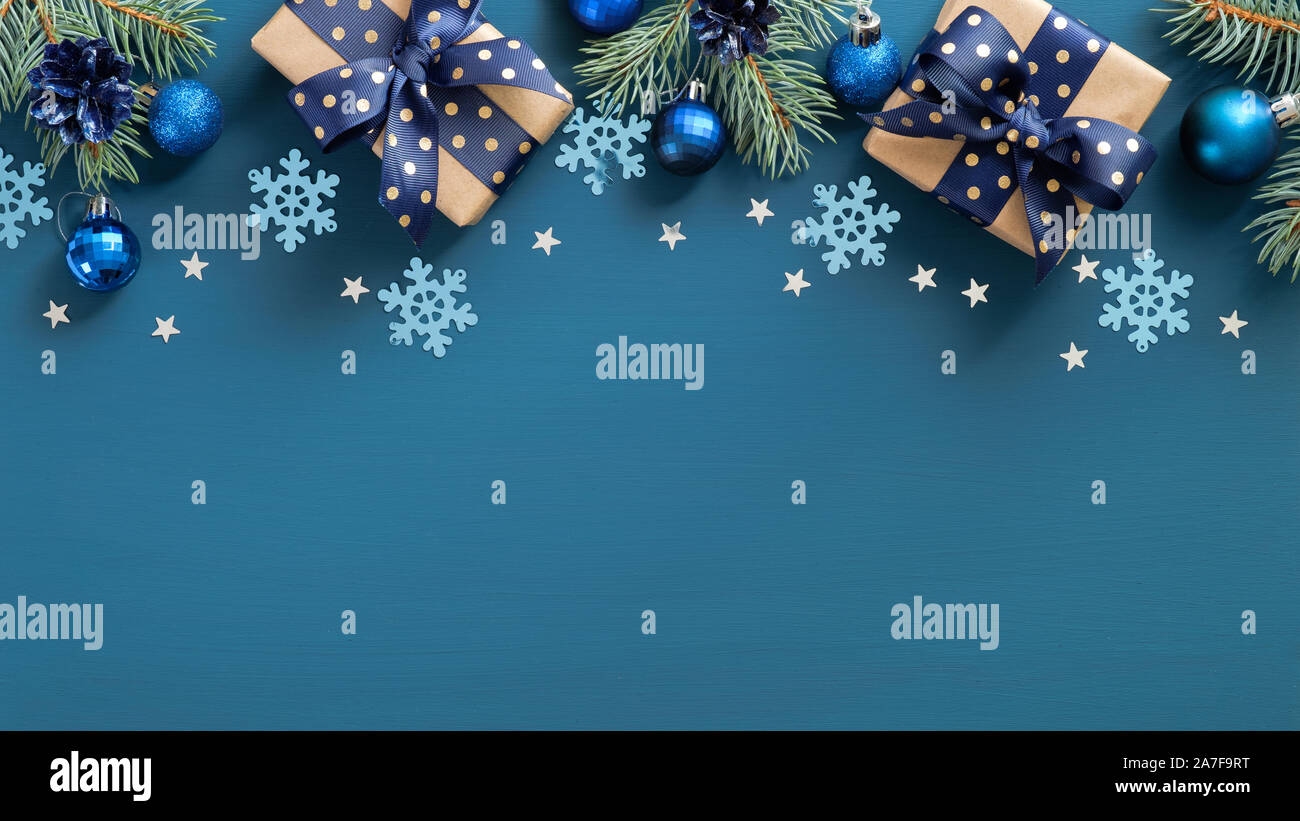 Natale Vintage bordo del frame. Piatto fir laici tre rami, palle blu e i fiocchi di neve su sfondo blu. Vista superiore, copia dello spazio. Saluto Anno Nuovo c Foto Stock