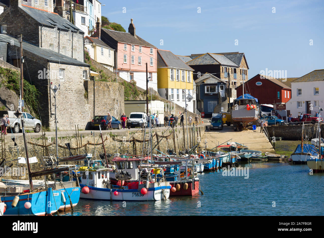 Mevagissey harbour con imbarcazioni al dispositivo di ancoraggio e pittoresche e colorate fishermens cottages Foto Stock
