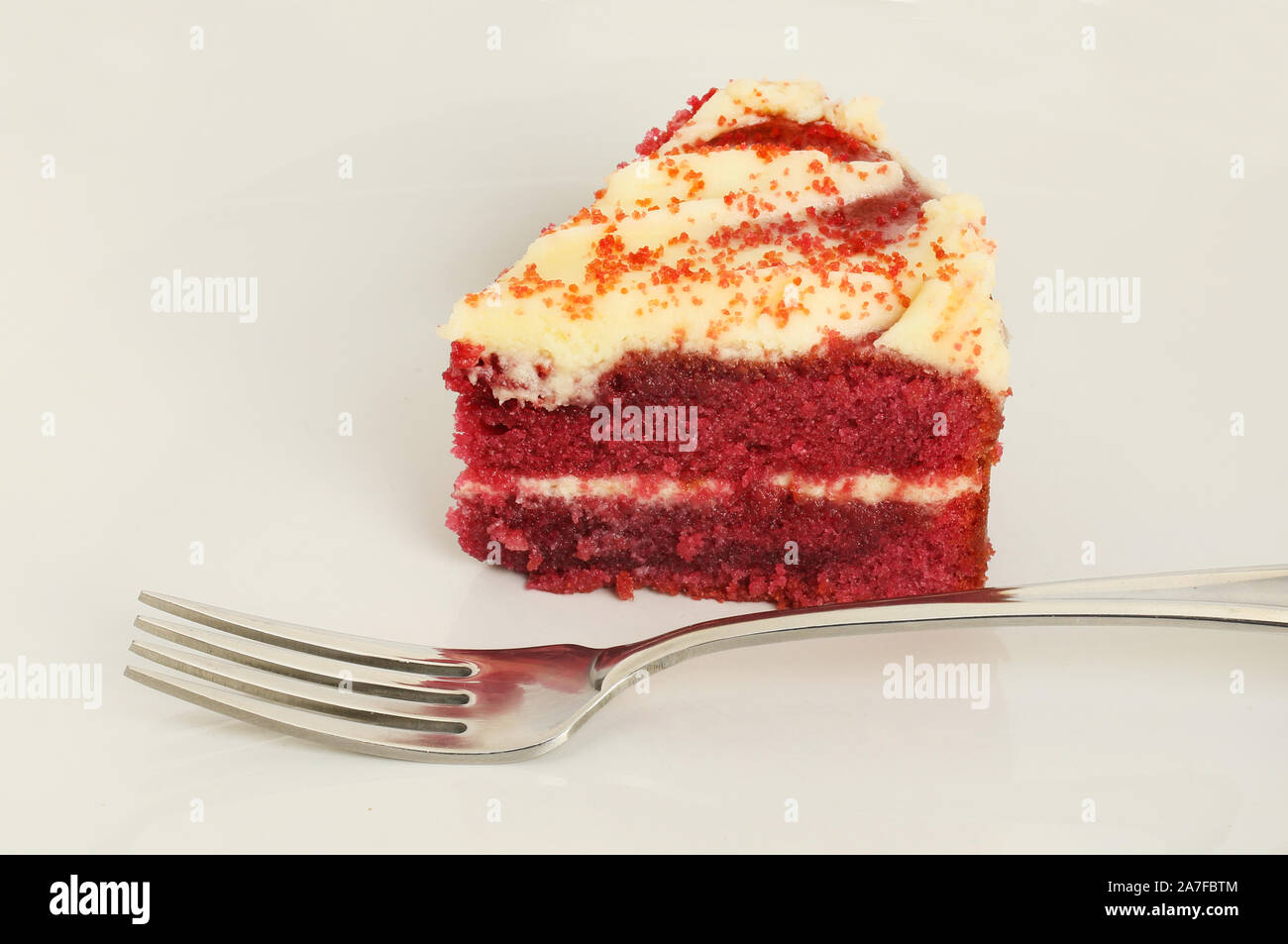 Primo piano di una fetta di torta rossa del velluto su una piastra con una forcella Foto Stock