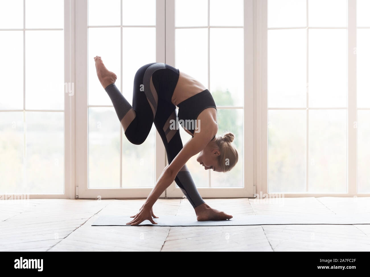 Giovane donna yoga toccando il suo ginocchio con la fronte Foto Stock