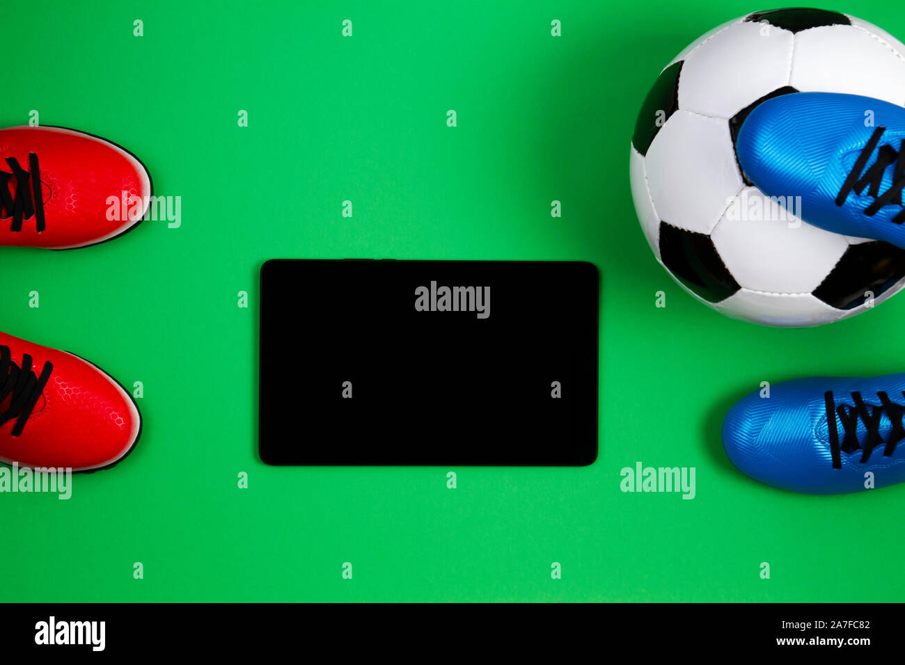 Calcio sfondo con scarpe da calcio, sfera e tablet pc su sfondo verde.  Vista superiore Foto stock - Alamy