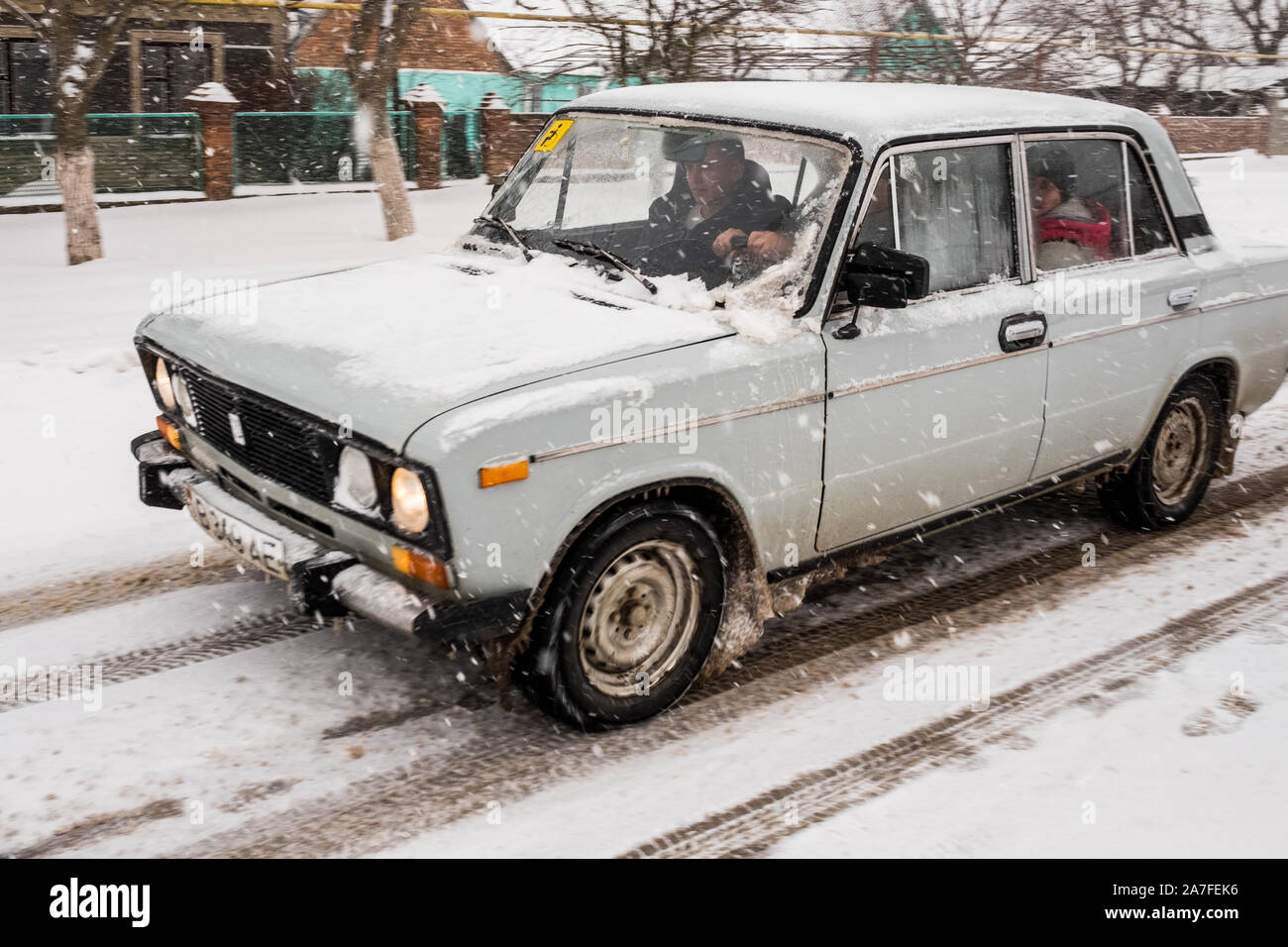 Un vecchio Russian Lada si fa strada lungo una strada innevata. Immagine presa nel paese sconosciuto della Transnistria noto anche come Pridnestrovie Foto Stock