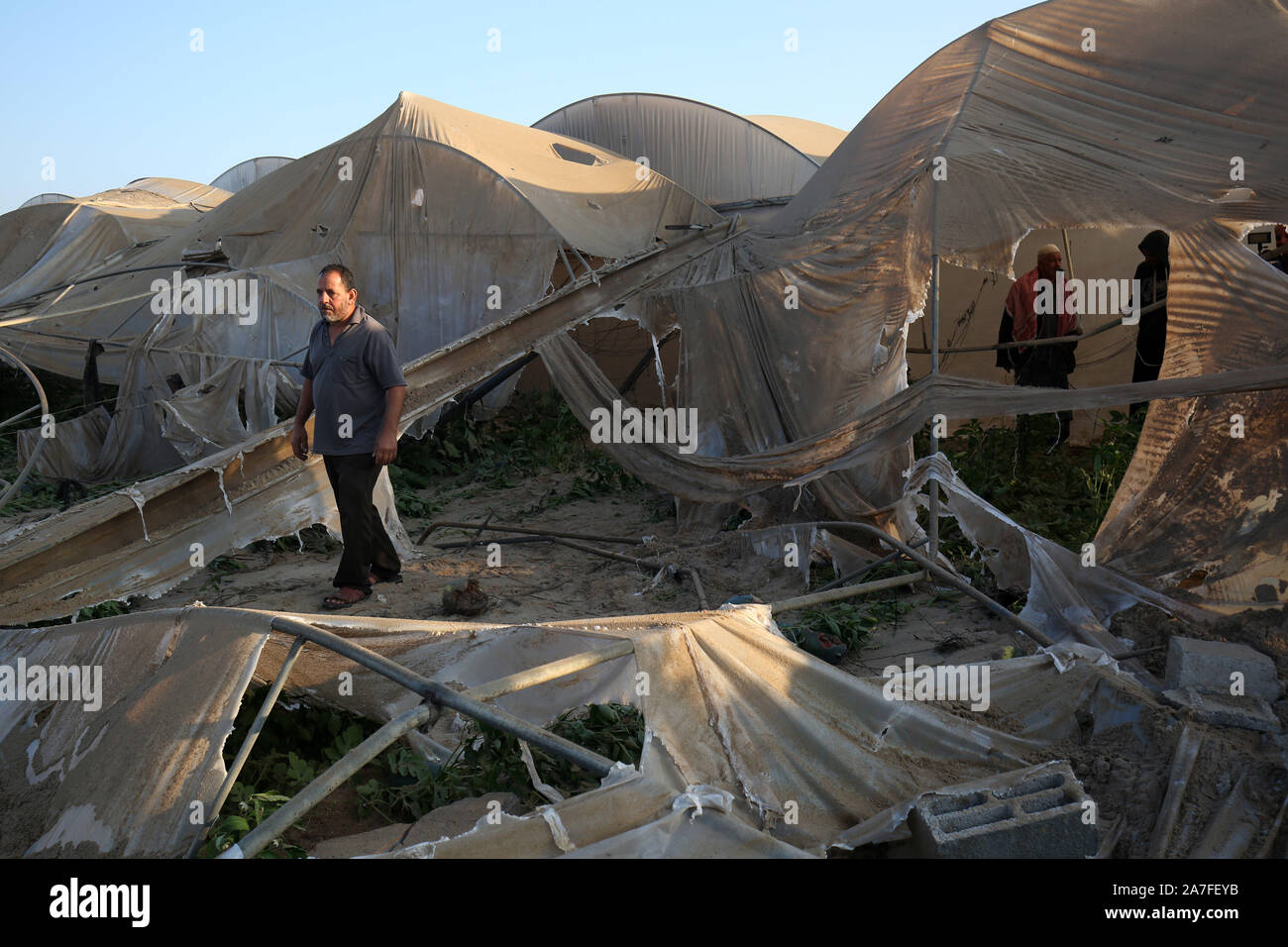 Khan Younis, Gaza. 02Nov, 2019. Un uomo palestinese passeggiate fra le serre danneggiate da un Israeliano airstrike ha lanciato, in Khan Yunis nel sud della striscia di Gaza il 2 novembre 2019. Decine di scioperi colpire l enclave palestinese nelle prime ore di oggi. una fonte di sicurezza a Gaza ha detto. Foto di Ismael Mohamad/UPI. Credito: UPI/Alamy Live News Foto Stock