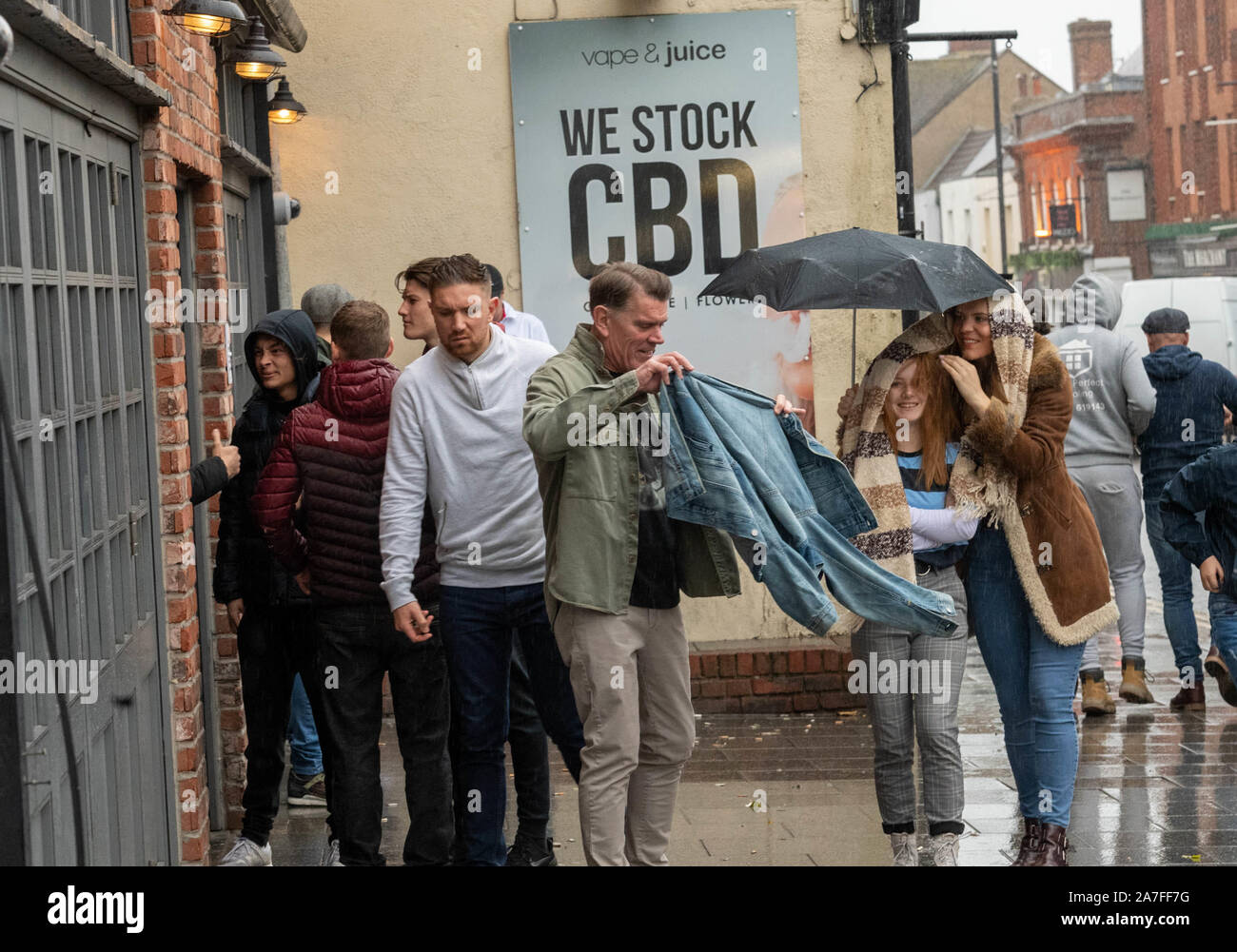 Brentwood, Essex, Regno Unito. 2 Nov 2019. Tifosi inglesi sotto la pioggia al di fuori di un pub a guardare l'Inghilterra vs Sud Africa rugby gioco. Credito: Ian Davidson/Alamy Live News Foto Stock