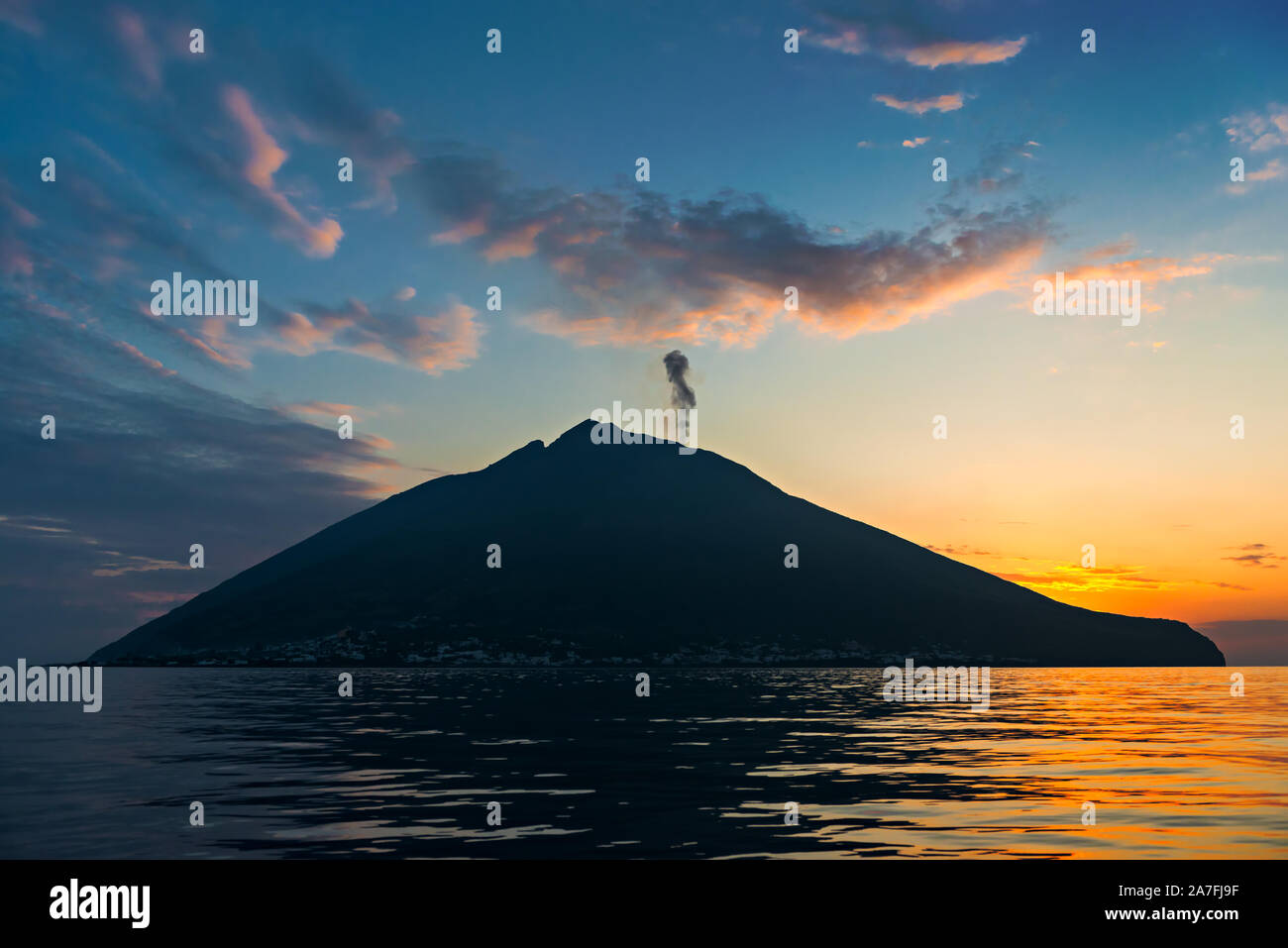 Vulcano Stromboli island silhouette al tramonto, mare calmo, blu e arancione torbida del cielo della sera, isole Eolie, Sicilia, Italia Foto Stock