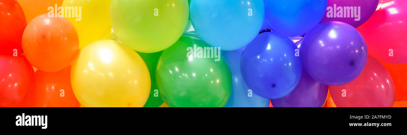 Ampia celebrazione banner con sfondo arcobaleno palloncini multicolori. Foto Stock