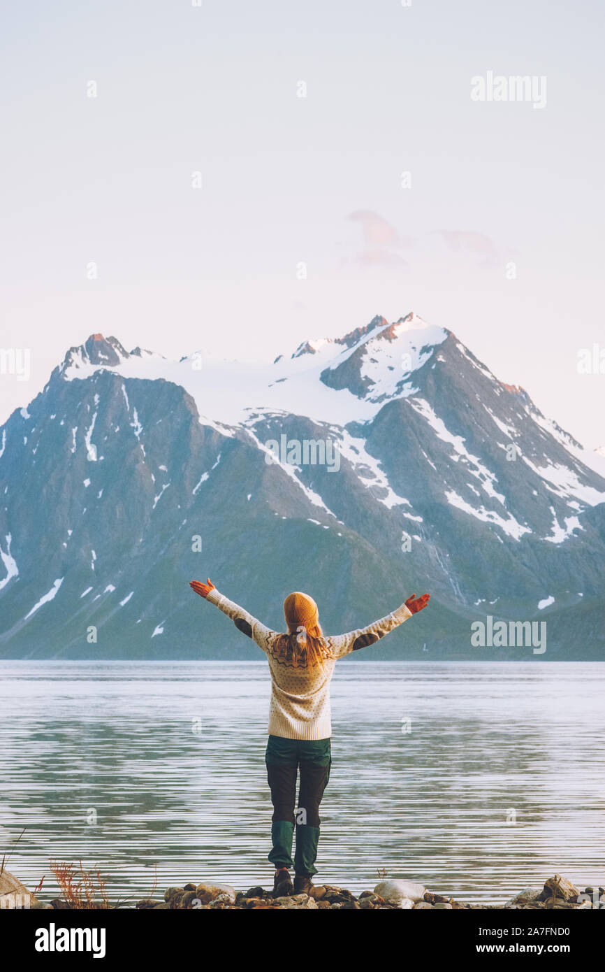 Donna felice le mani alzate godendo la Norvegia vista montagne Viaggi Vacanze avventura di uno stile di vita sano concetto di libertà Lyngen Alpi e paesaggio del fiordo Foto Stock