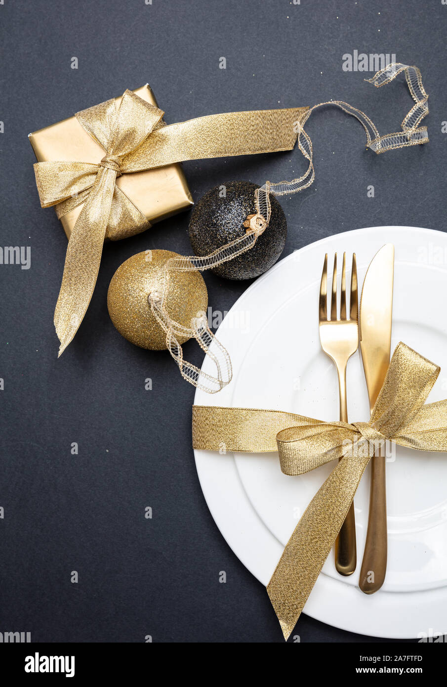 Tavola di natale l'impostazione. Posate in oro bianco e set di stoviglie su sfondo nero, vista dall'alto Foto Stock