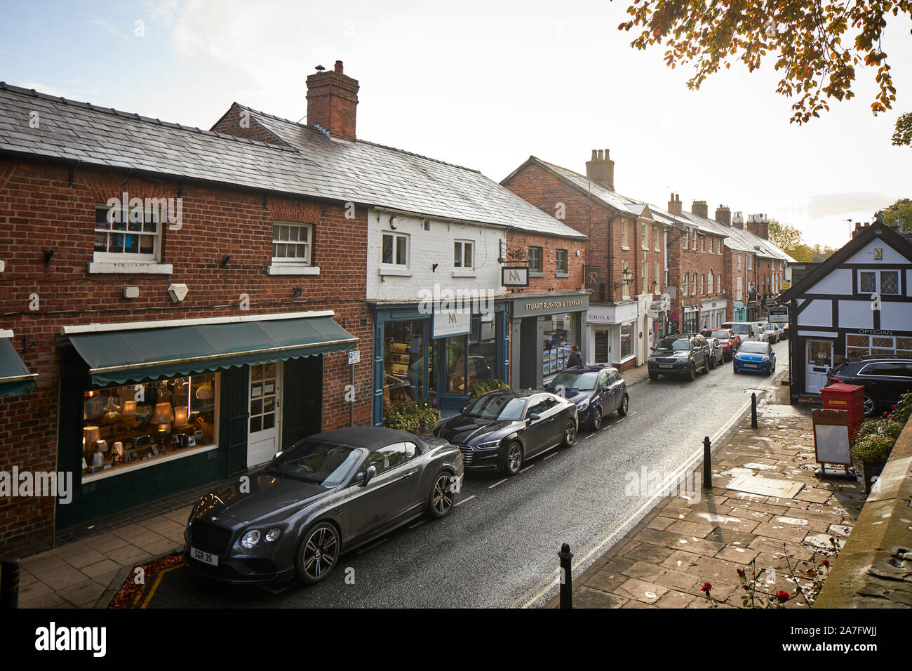 Città Knutsford, Cheshire. King Street, la strada principale dello shopping di strada stretta con macchine parcheggiate Foto Stock