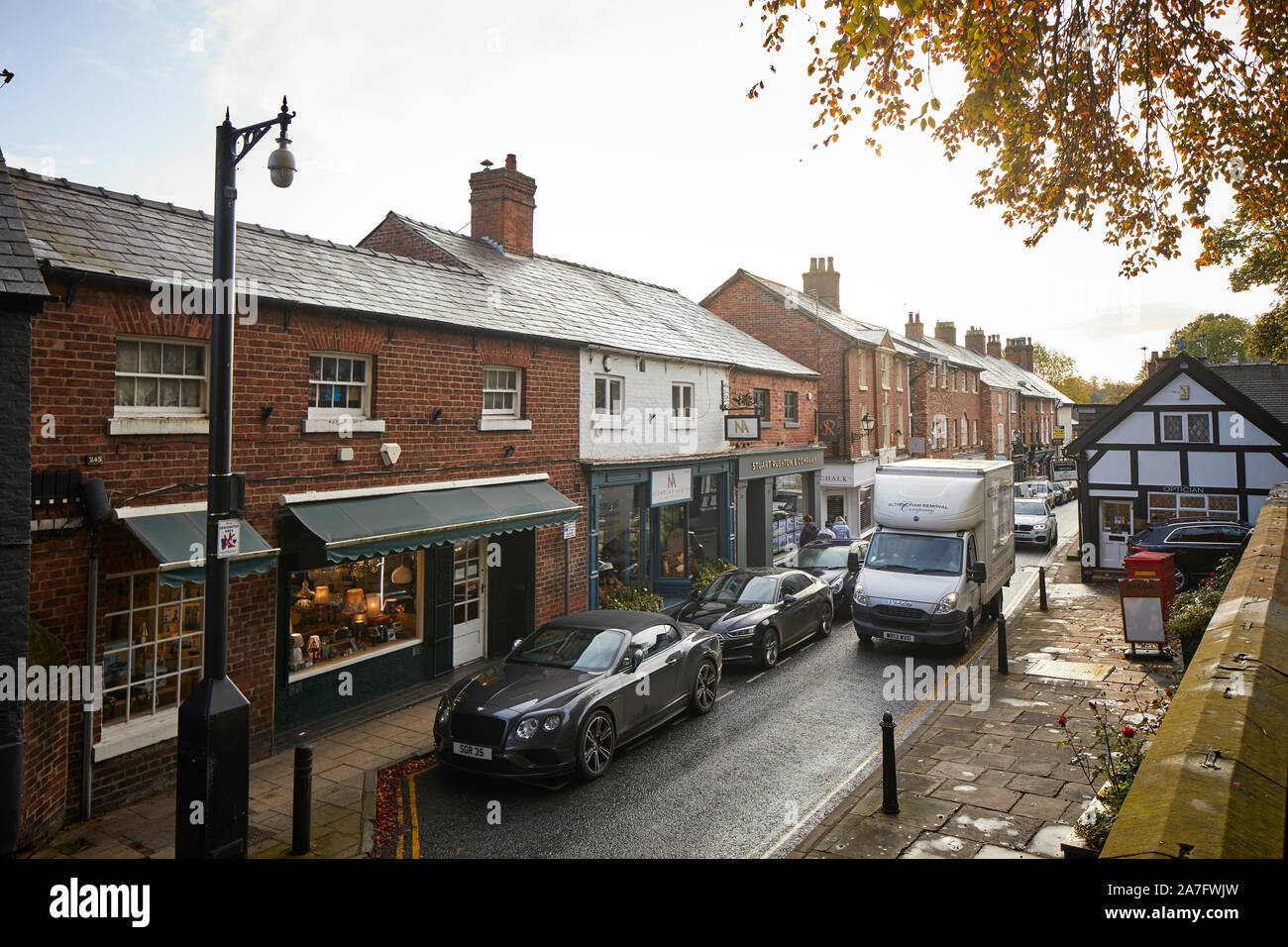 Città Knutsford, Cheshire. King Street, la strada principale dello shopping di strada stretta con macchine parcheggiate Foto Stock