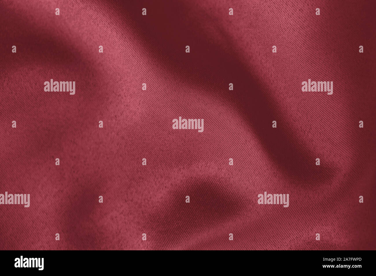 Colore rosso scuro sullo sfondo di un morbido tessuto drappeggiato. Bella raso di seta tessuto a trama per la realizzazione di abiti e tende. Elegante texture tessili. Foto Stock