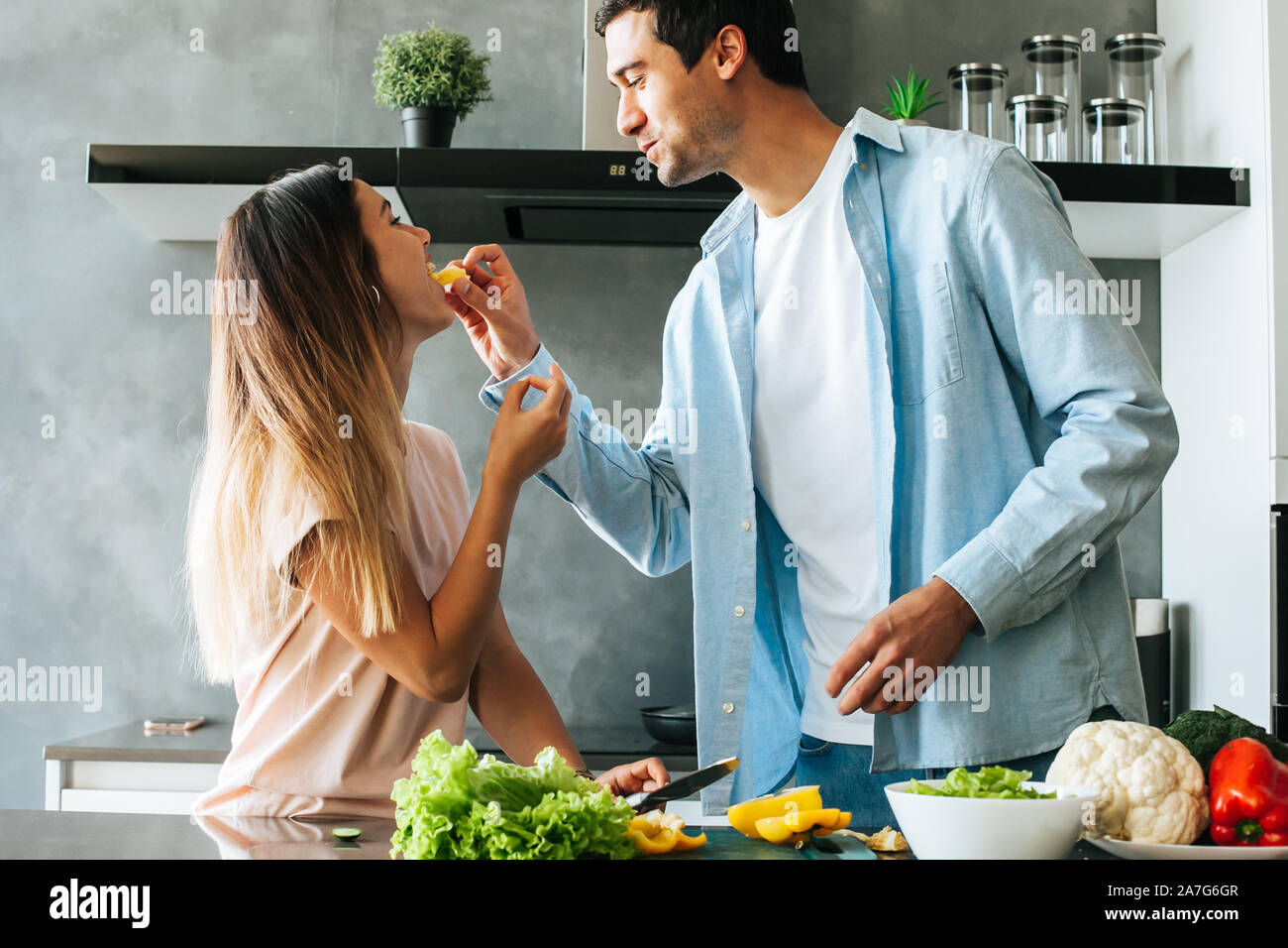 Felice coppia giovane abbracciando durante la colazione nella cucina Foto Stock